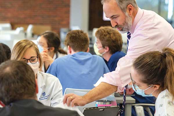 Dr. Chad Miller working hands on with a student