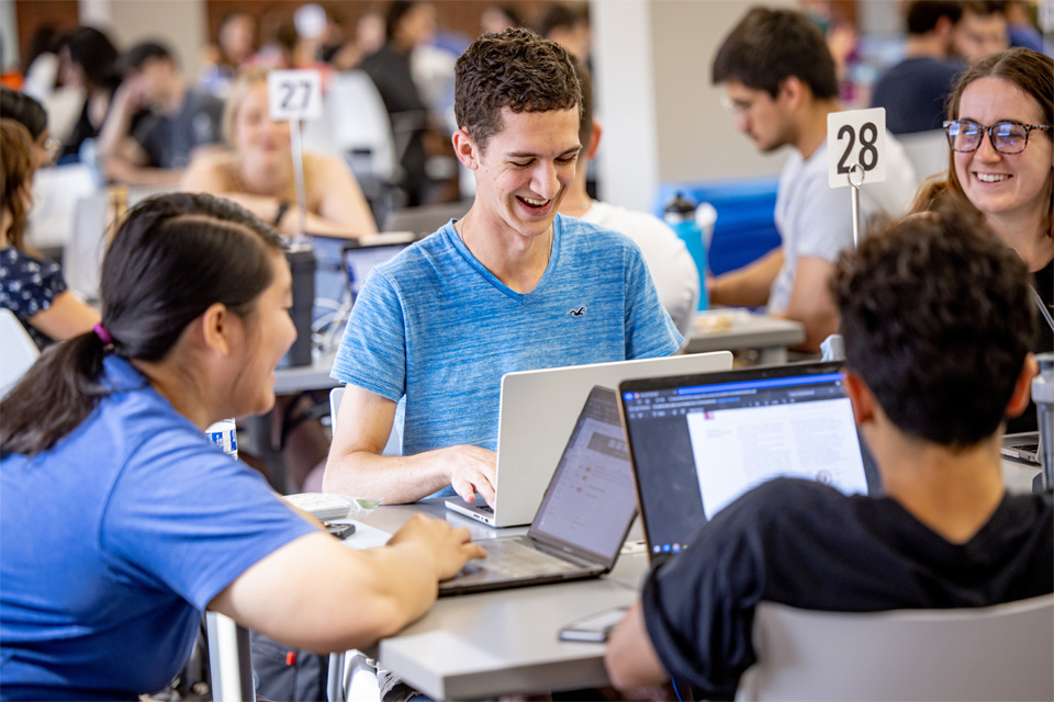 Group of students working together in the 360 classroom where most of the curriculumn is taught for earlier medial students