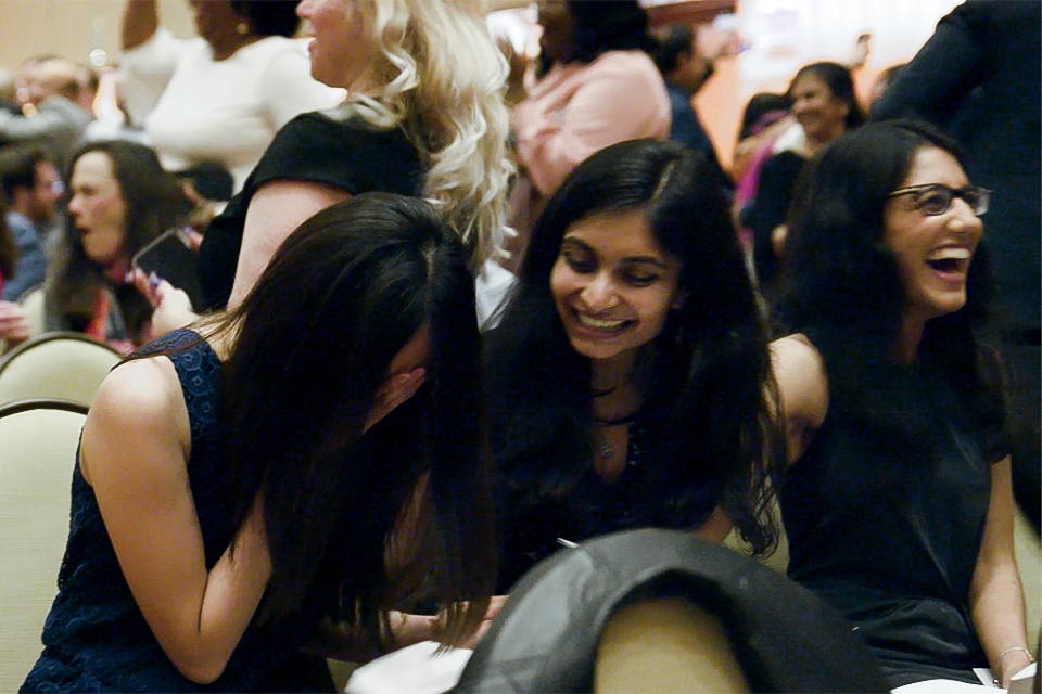 Shot of two students recieving their match day envolpes and being very excited 